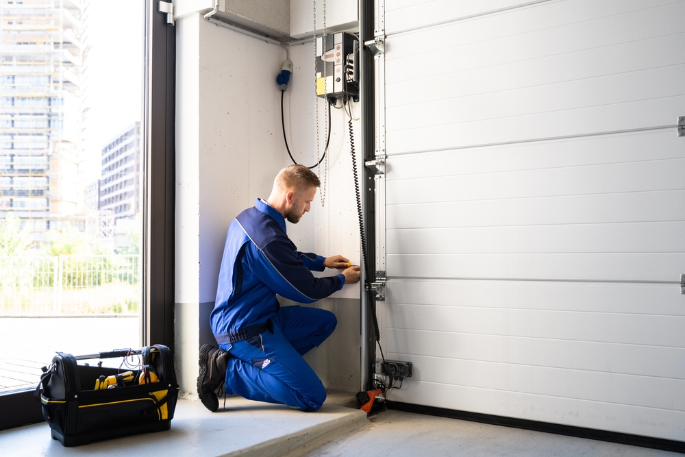A professional inspecting a garage door - Should You Have Your Garage Door Serviced Every Year?
