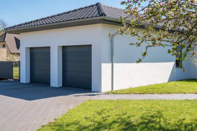 Modern and luxurious double garage with driveway and roll-up door, exemplifying the importance of fully licensed and insured garage door repair in New Orleans