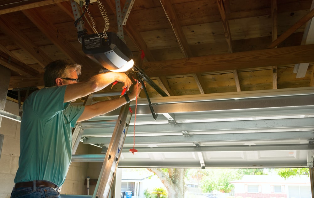 A skilled garage door repair technician working on a ladder in a residential home setting, making adjustments and repairs during installation.