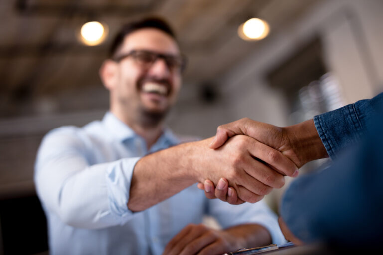 Businessmen shaking hands, signifying a trusted partnership between companies in the garage door repair industry.