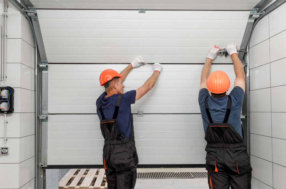 Workers installing lift garage doors, demonstrating the professional services offered by Ace Garage Door LLC in New Orleans.