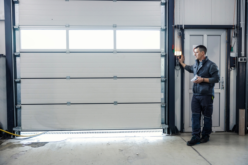 A mechanic pressing a button and opening a garage door. garage door repair in new orleans - ace garage door
